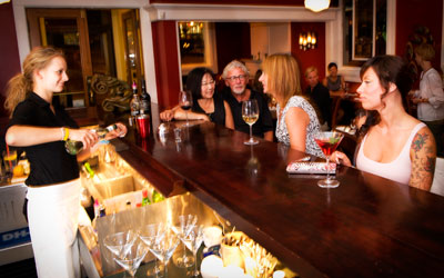 A bartender pouring drinks for people at the bar at Brownstone Restaurant.